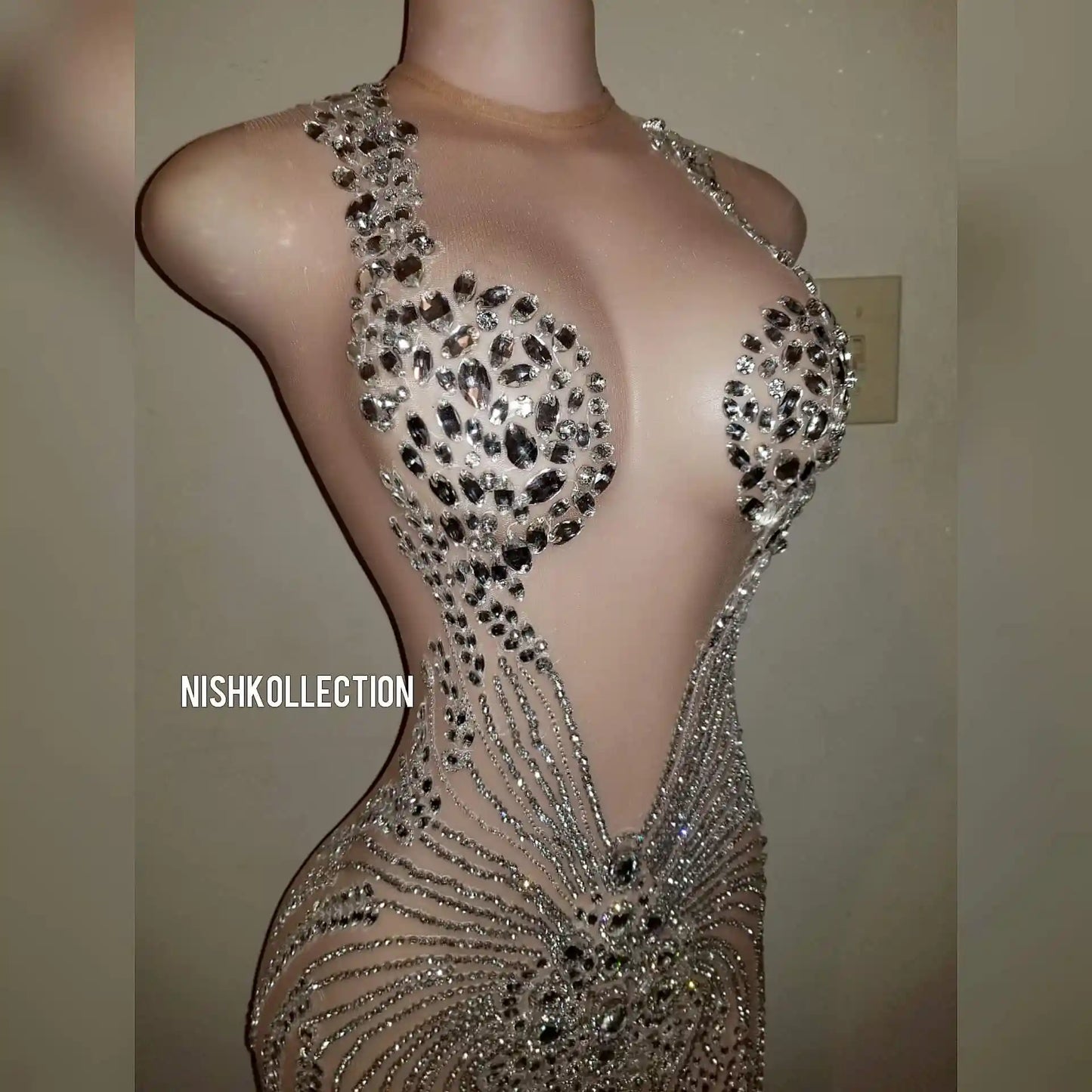 Close-up of rhinestone detailing on luxury mesh mini dress.