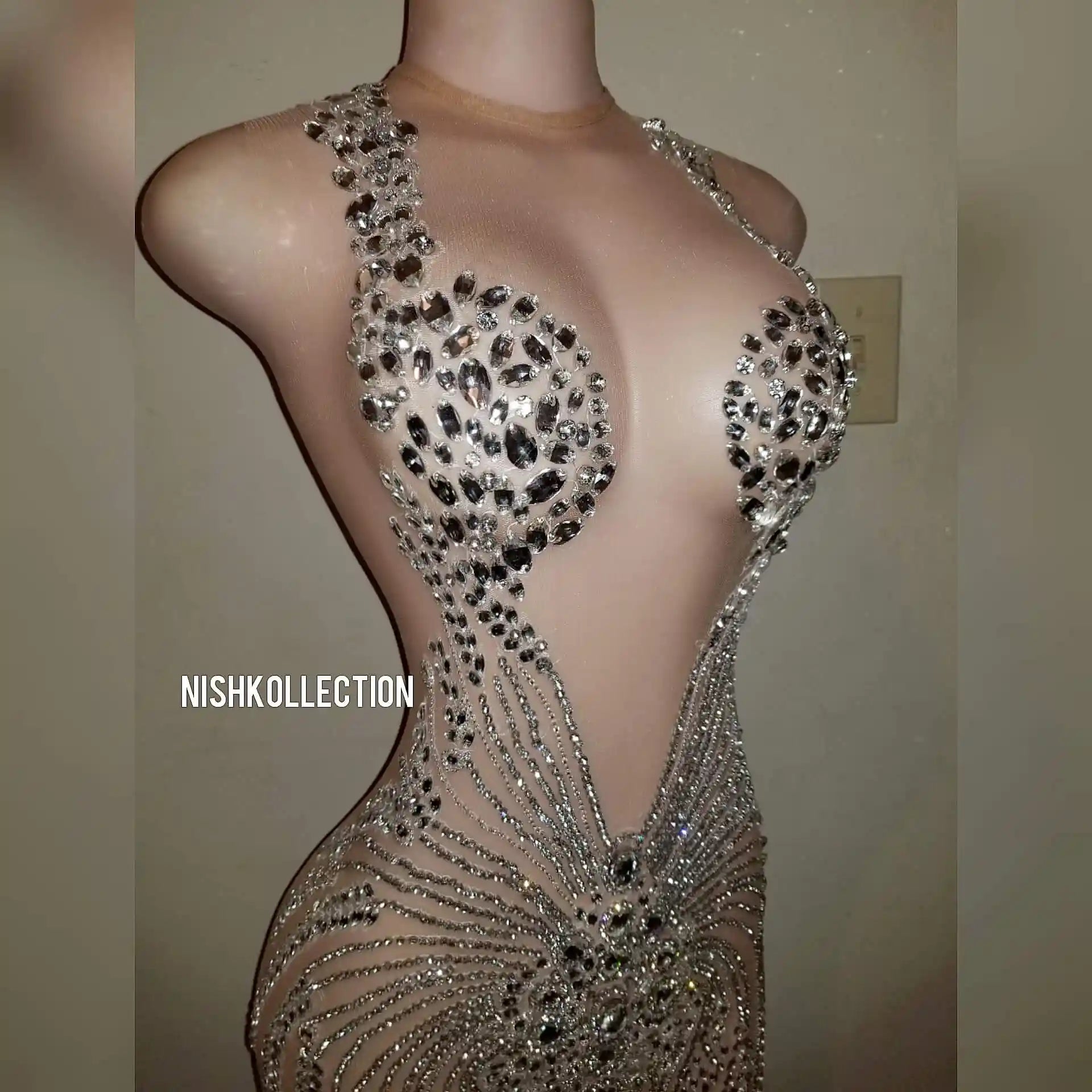 Close-up of rhinestone detailing on luxury mesh mini dress.